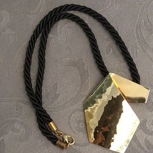 Hammered metal necklace on thick black cord